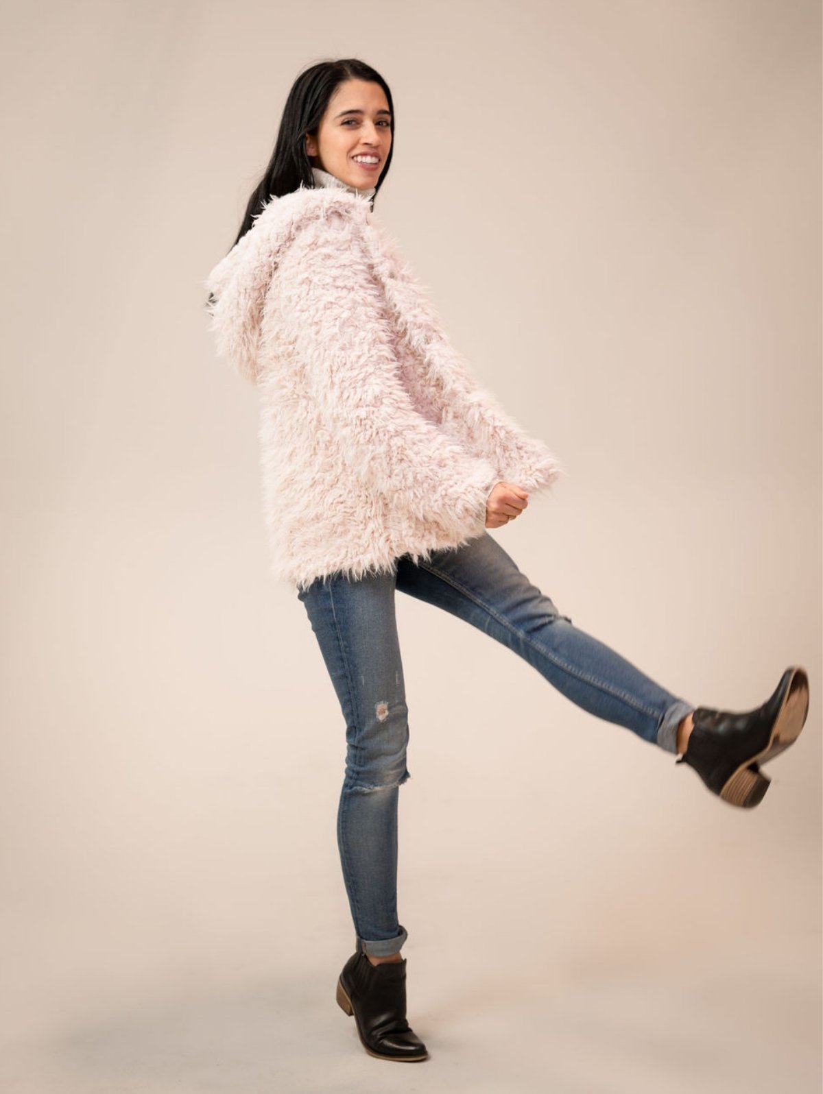 Ashley wearing the Shine Your Light coat while kicking her foot up