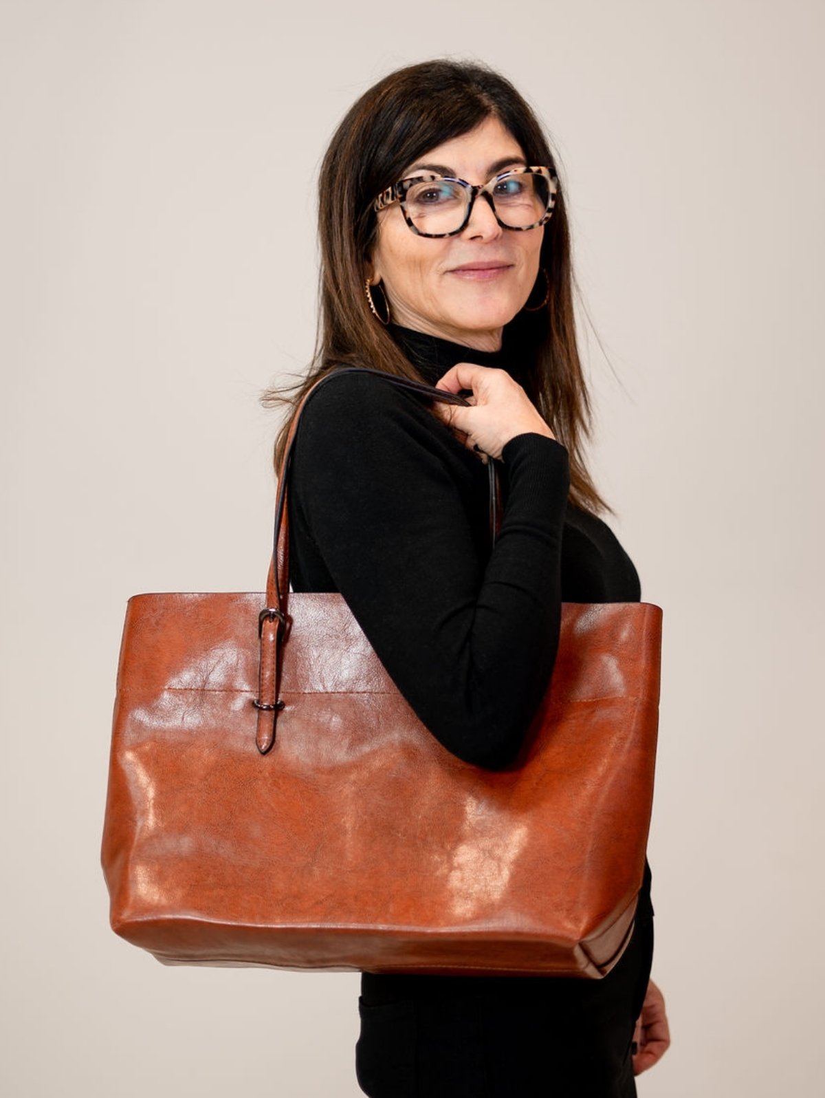 Elizabeth wearing a black shirt with the Road Less Traveled Tote on her shoulder