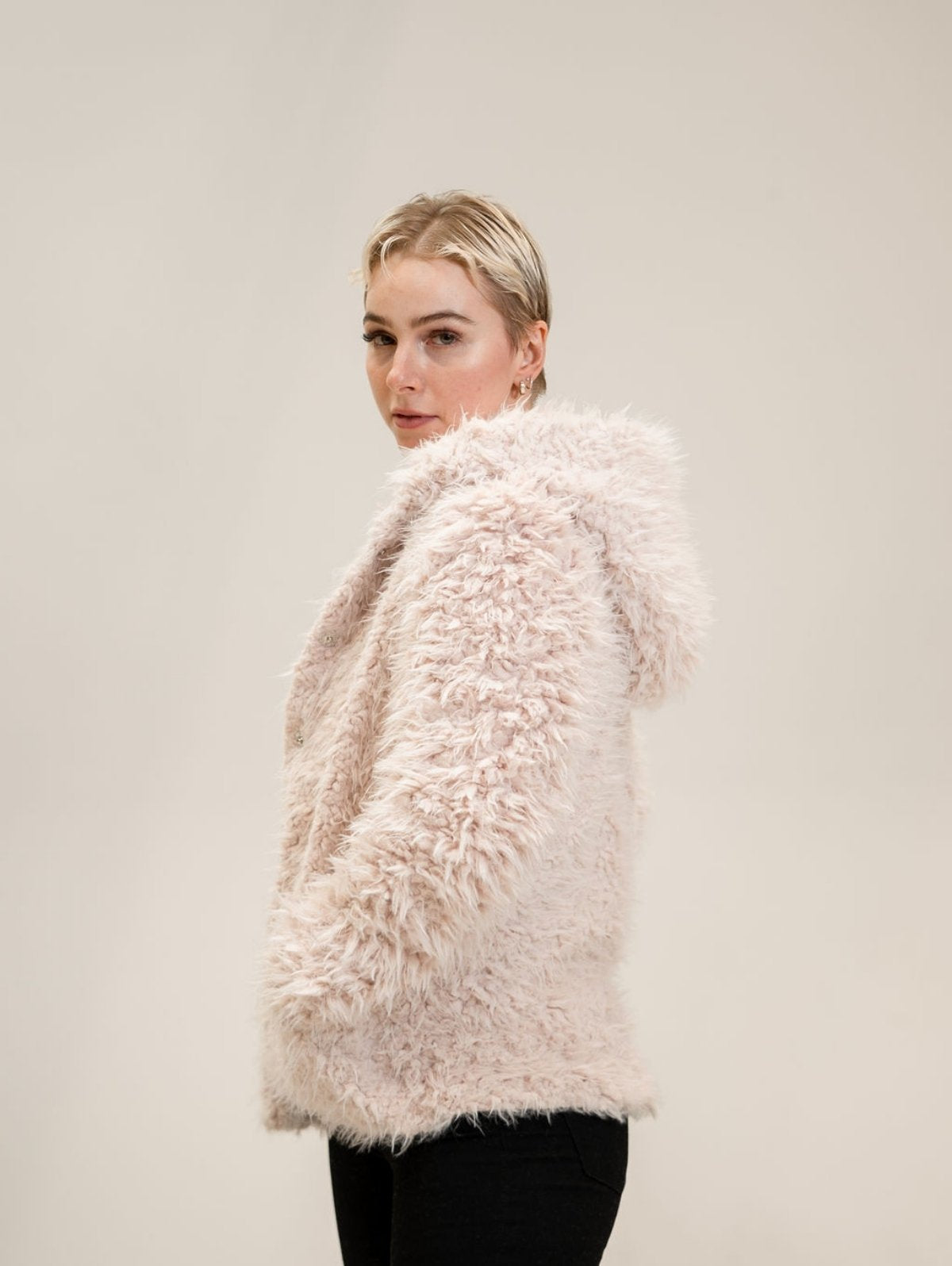 Julia turned to the side and looking at the camera while wearing the Shine Your Light coat